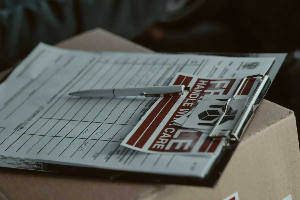 Close-up of delivery paperwork on a clipboard resting on a freight box